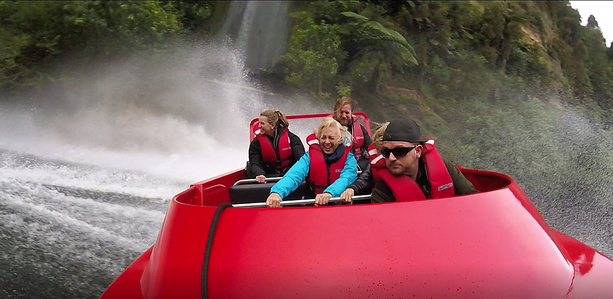 Camjet jet boat with 5 people on board doing a 360 degree spin in front of the big water fall.